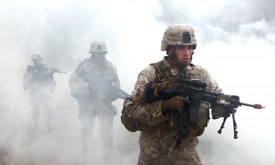 U.S. Marines with Fox Company, Battalion Landing Team 2/6, 26th Marine Expeditionary Force, use a smoke grenade to screen their movement as they prepare to enter a building during military operations in urban terrain (MOUT) training at Fort Pickett, Va., April 11, 2015