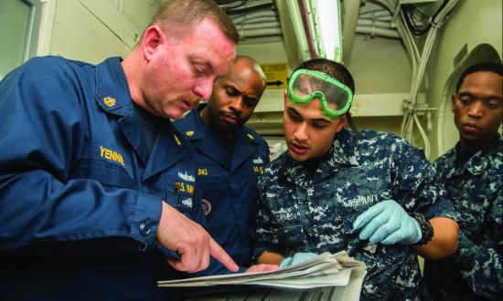 Chief Electronics Technician Douglas Yennie, a 3M supervisor, briefs sailors on the maintenance of the USS Harry S.  Truman (CVN-75). 