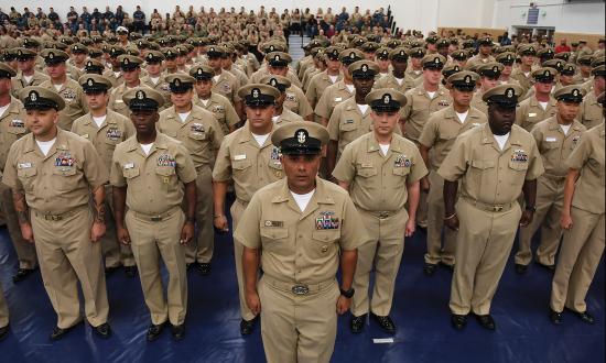 Members of Naval Station Mayport's Chief's Mess stand at attention during a Chief Petty Officer pinning ceremony at the base gy